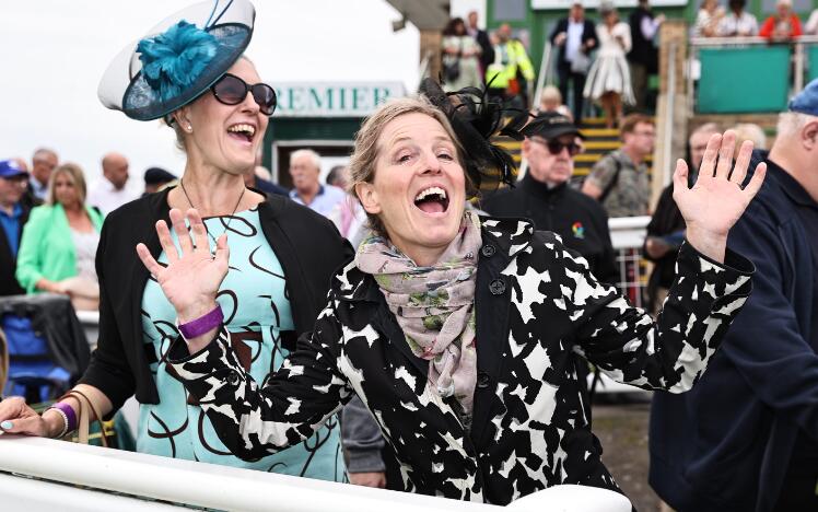 Two ladies having fun and pulling a pose for the camera at Great Yarmouth races